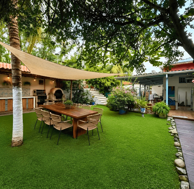 Área gourmet com mesa externa e jardim