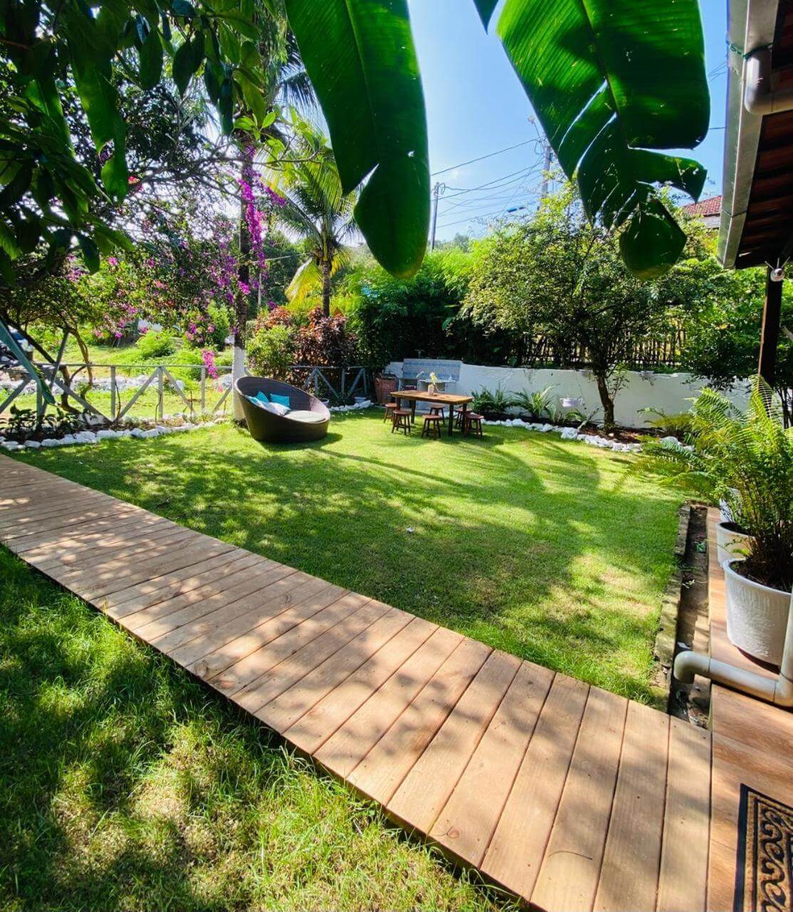 Área externa com sofá e jardim